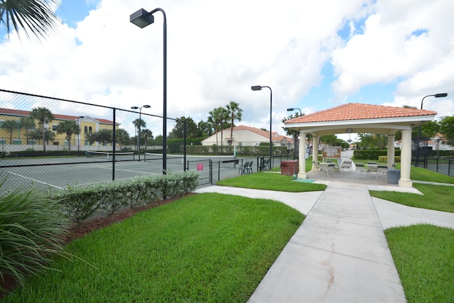 view of property's community with tennis court, a gazebo, and a yard