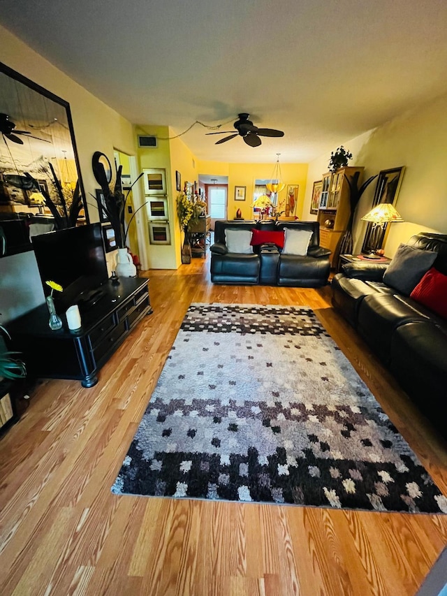 living room featuring ceiling fan and hardwood / wood-style flooring