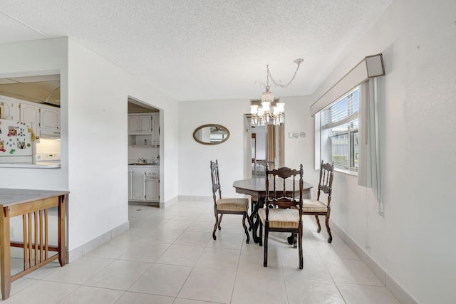 dining area with a chandelier, a textured ceiling, and light tile flooring