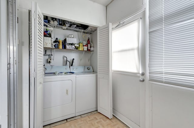 laundry area with light parquet flooring and washing machine and dryer