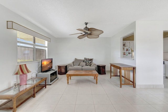 tiled living room featuring ceiling fan and a textured ceiling