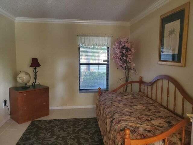 tiled bedroom with a textured ceiling and ornamental molding