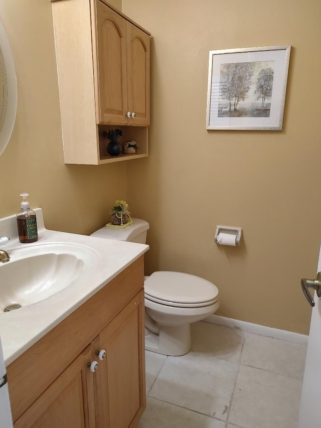 bathroom featuring tile flooring, vanity, and toilet