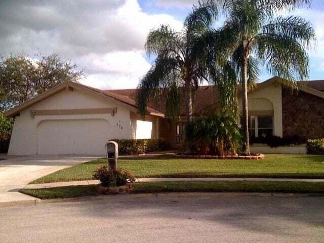 single story home with a garage and a front lawn