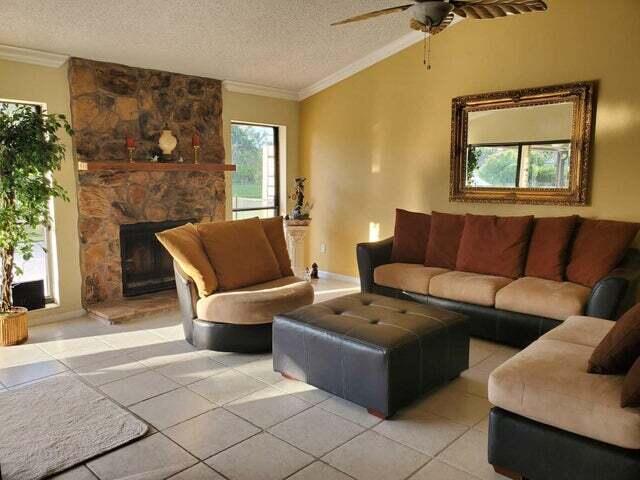 living room featuring tile floors, ceiling fan, a textured ceiling, and a fireplace