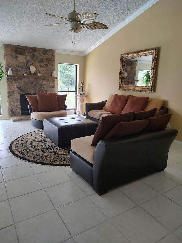 tiled living room with ornamental molding, ceiling fan, a textured ceiling, and a fireplace