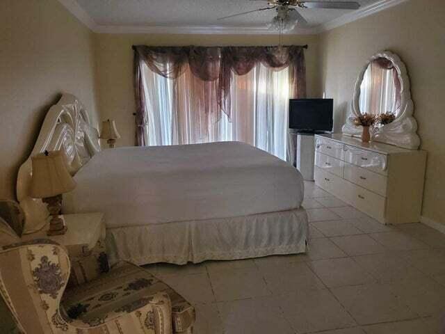 bedroom featuring ceiling fan, tile floors, and crown molding