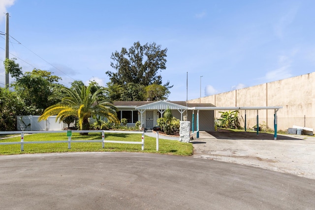 ranch-style home with a front lawn and a carport