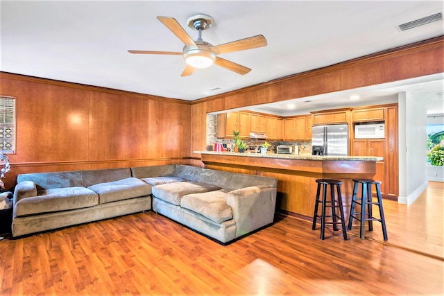 living room with light hardwood / wood-style floors and ceiling fan