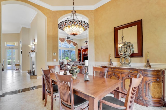 tiled dining room featuring a wealth of natural light, ceiling fan, crown molding, and a towering ceiling