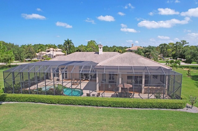 rear view of property with a lawn, a lanai, and a patio