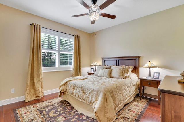 bedroom with dark hardwood / wood-style flooring and ceiling fan