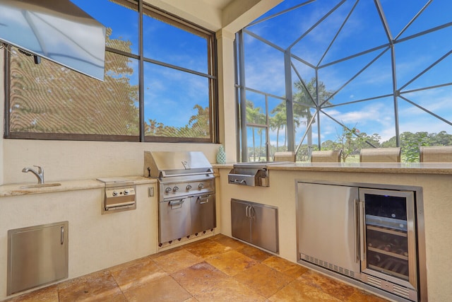 view of terrace featuring a lanai, exterior kitchen, sink, and grilling area