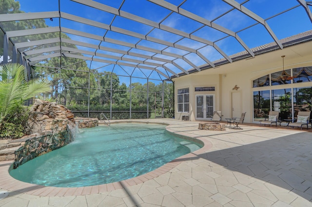 view of swimming pool featuring pool water feature, ceiling fan, a lanai, and a patio