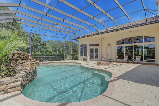 view of swimming pool with a patio area, ceiling fan, and a lanai