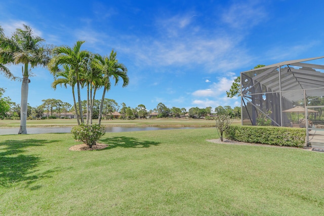 view of yard with a water view and glass enclosure