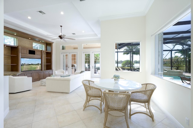 tiled dining area featuring a tray ceiling, ceiling fan, french doors, and ornamental molding