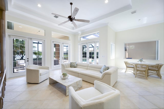 tiled living room with a tray ceiling, french doors, and a wealth of natural light