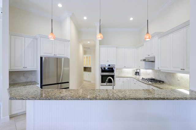 kitchen with decorative light fixtures, backsplash, white cabinetry, and appliances with stainless steel finishes