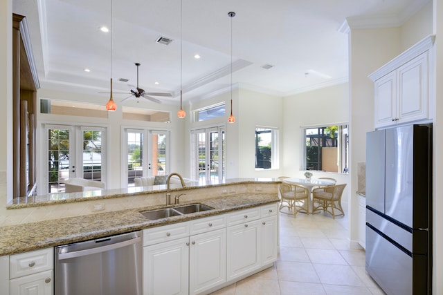 kitchen with stainless steel appliances, a tray ceiling, white cabinetry, sink, and french doors