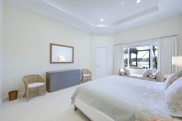 carpeted bedroom featuring a tray ceiling and ornamental molding