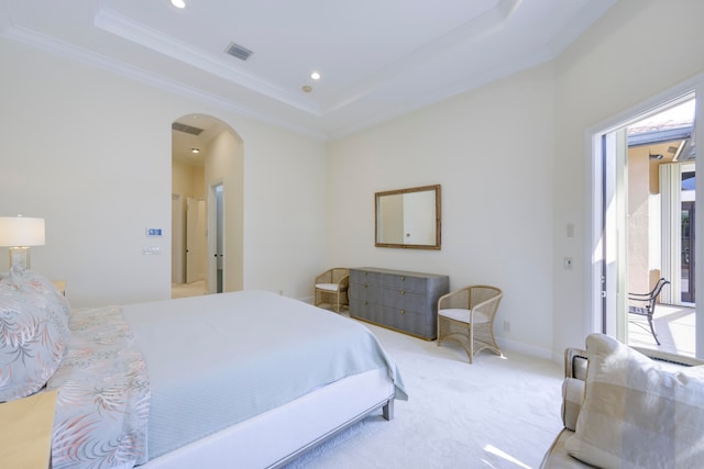 bedroom with carpet flooring, ornamental molding, and a tray ceiling