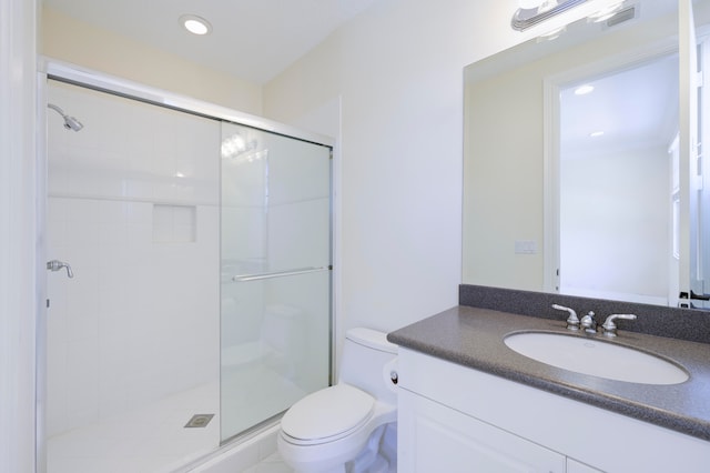 bathroom with vanity with extensive cabinet space, toilet, and a shower with door