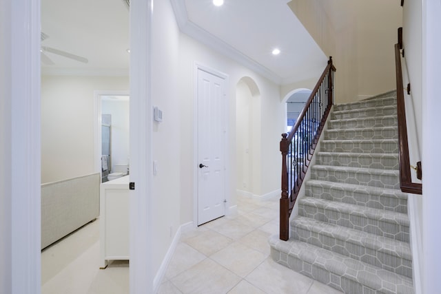 stairs with light tile floors and crown molding