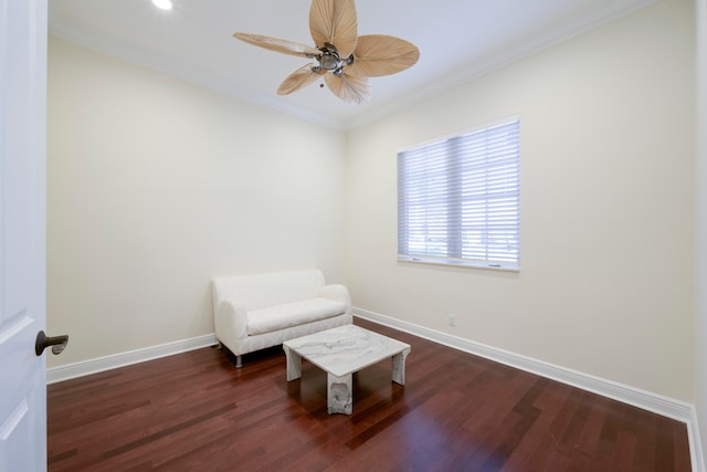 living area with crown molding, dark hardwood / wood-style floors, and ceiling fan