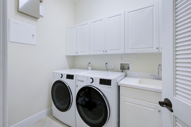 clothes washing area with cabinets, washing machine and clothes dryer, hookup for a washing machine, sink, and light tile floors