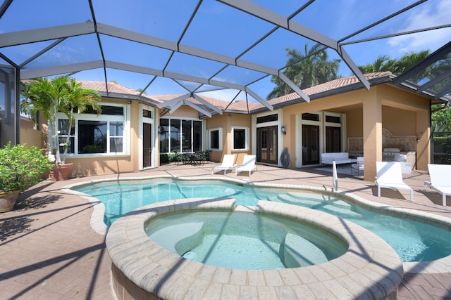 view of pool with glass enclosure, an in ground hot tub, and a patio area