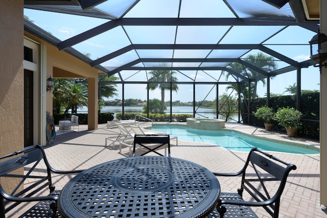 view of pool featuring an in ground hot tub, a patio, a lanai, and a water view