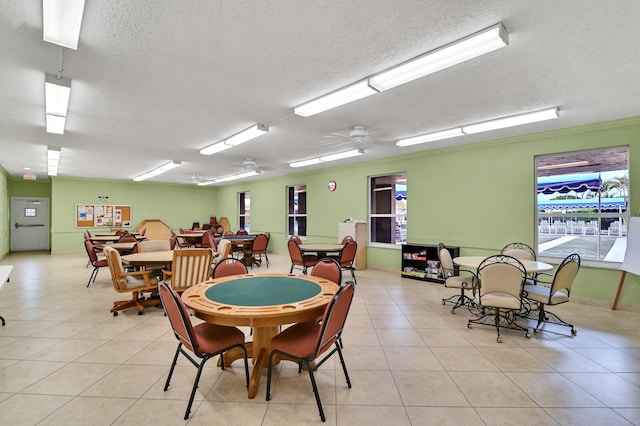 rec room featuring light tile patterned flooring, a textured ceiling, and ceiling fan