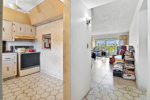 kitchen featuring lofted ceiling, light tile patterned floors, a textured ceiling, white electric stove, and ceiling fan