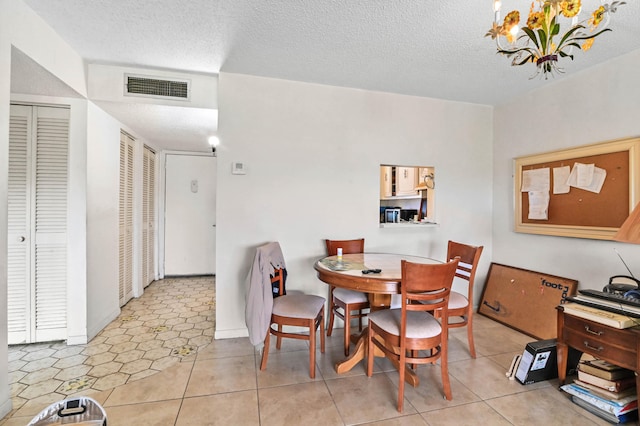 tiled dining space with a textured ceiling