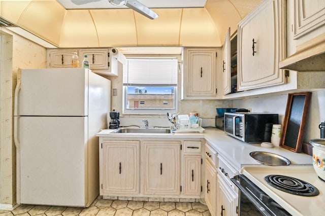 kitchen featuring range, white refrigerator, sink, light tile patterned floors, and ceiling fan