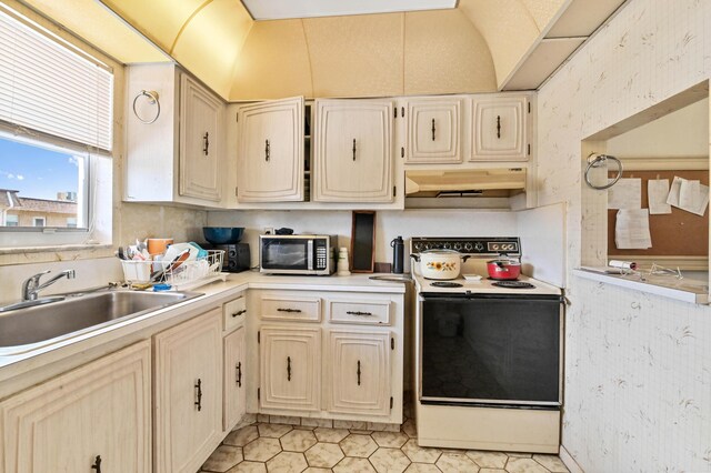 kitchen with light tile patterned flooring, sink, white electric stove, and lofted ceiling