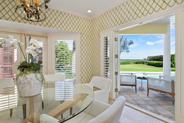 dining room featuring tile floors, an inviting chandelier, and ornamental molding