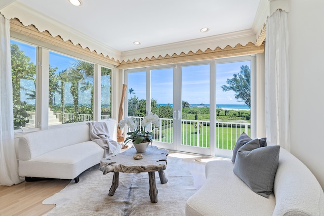 sunroom featuring a wealth of natural light and a water view