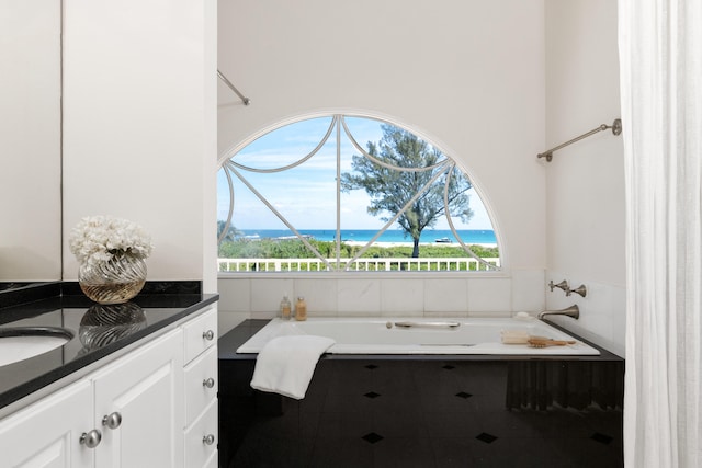 bathroom with a wealth of natural light, vanity, and a tub