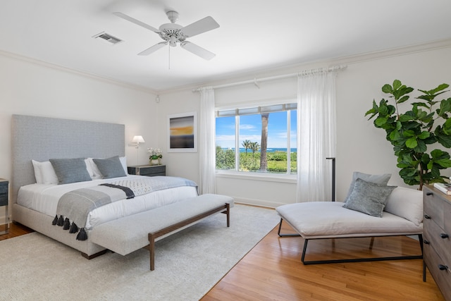 bedroom featuring hardwood / wood-style floors, ceiling fan, and crown molding