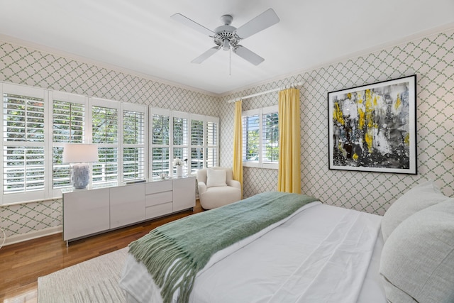 bedroom with ornamental molding, wood-type flooring, and ceiling fan