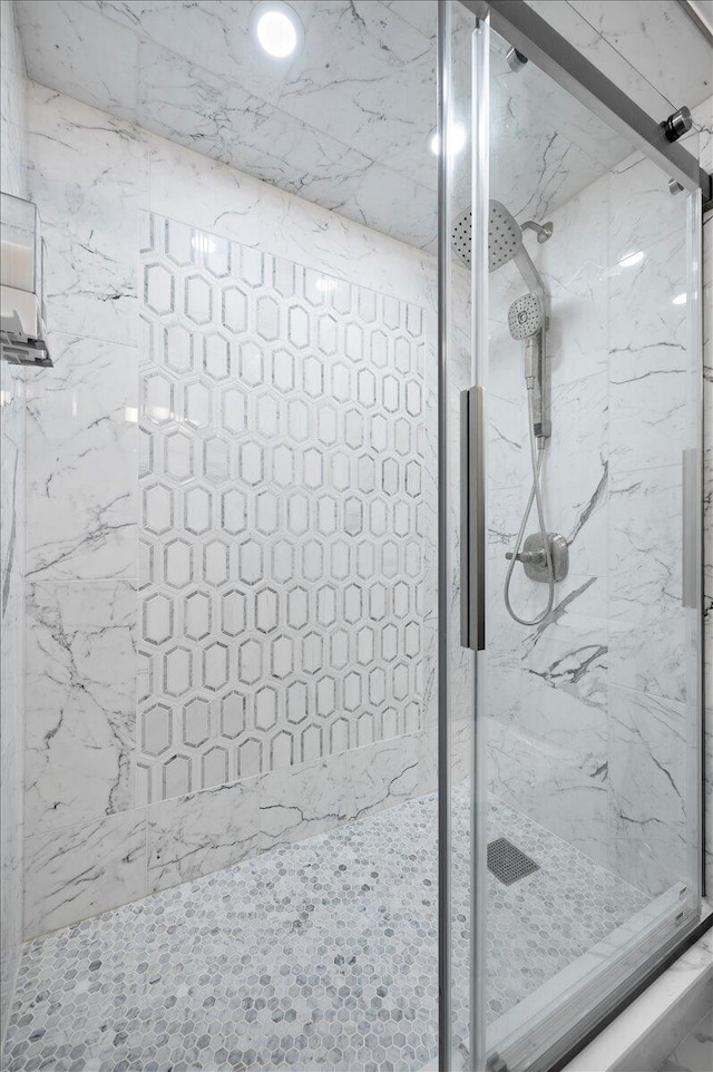 bathroom with a shower with door