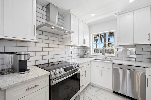 kitchen with light tile floors, wall chimney range hood, tasteful backsplash, white cabinetry, and stainless steel appliances