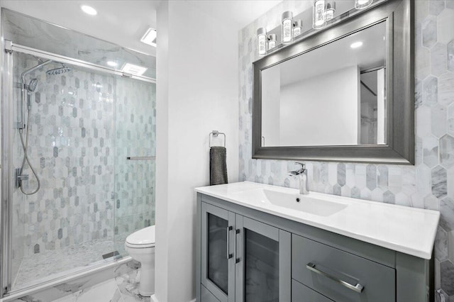 bathroom featuring tile floors, tile walls, vanity, a tile shower, and toilet