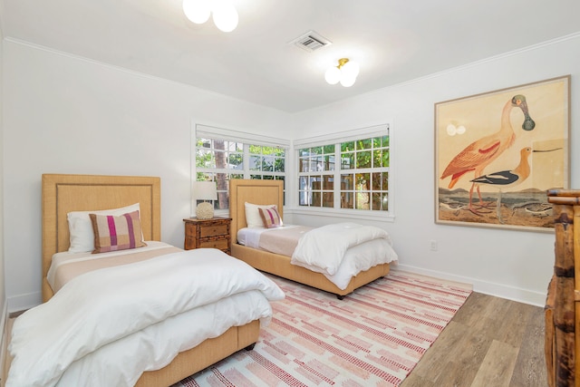 bedroom with wood-type flooring and ornamental molding