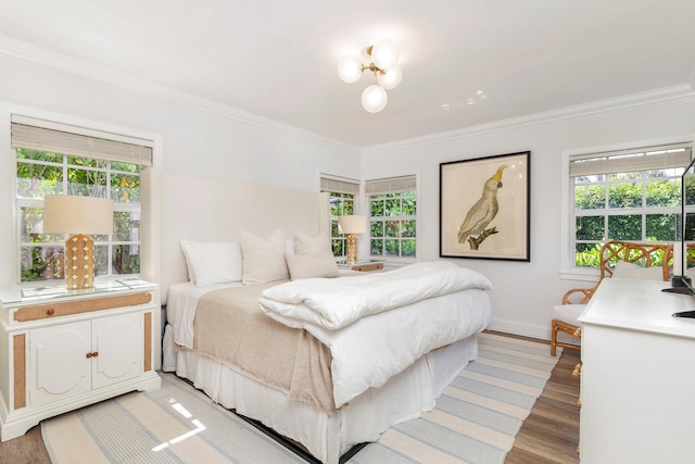 bedroom with hardwood / wood-style floors and ornamental molding