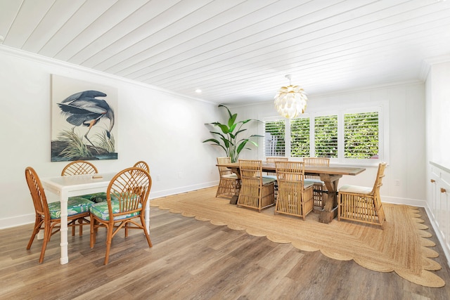 dining room featuring ornamental molding, wood-type flooring, and an inviting chandelier