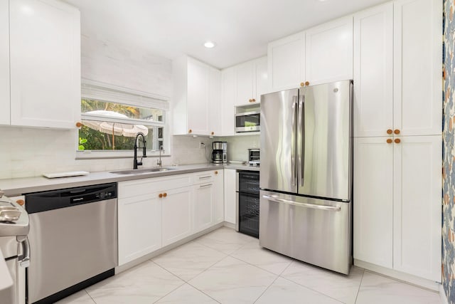 kitchen featuring stainless steel appliances, white cabinets, sink, and light tile floors