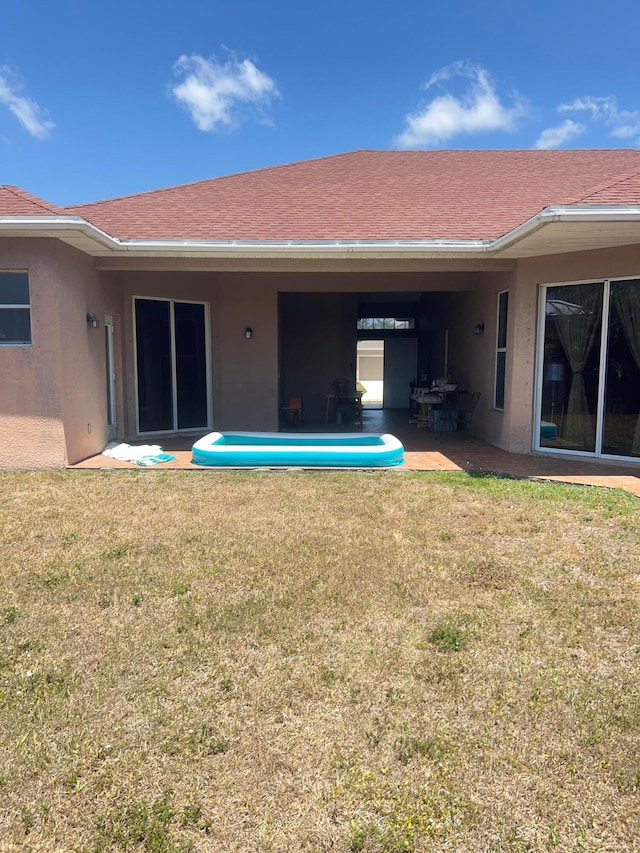 back of house featuring a patio area and a yard